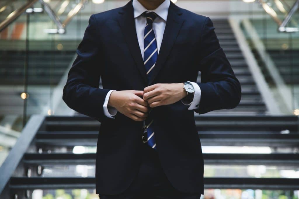 A man wearing a suit standing near the stair