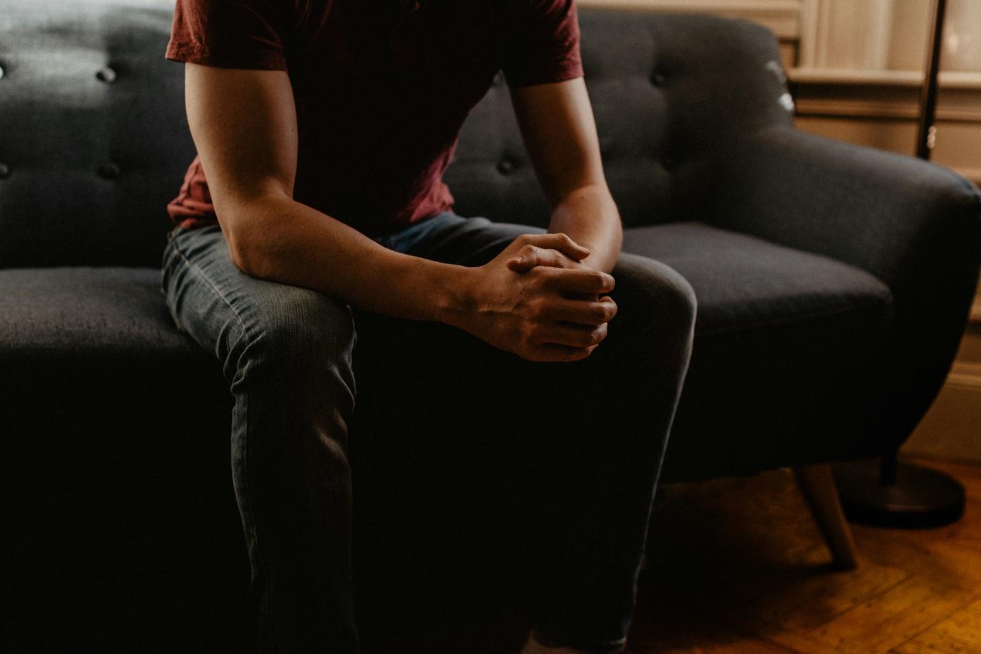 A person sitting on a couch Description automatically generated